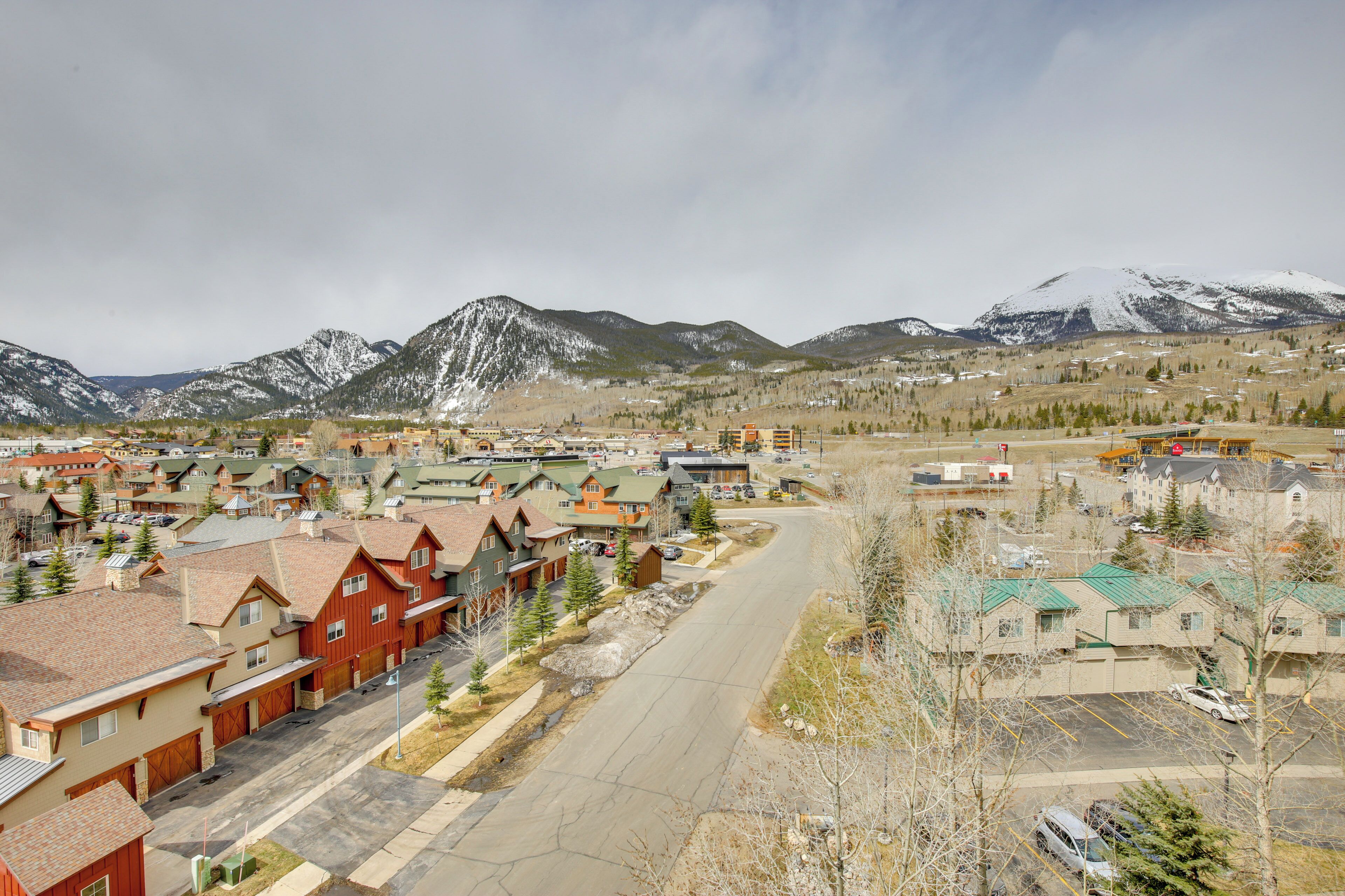 A residential area with houses, a main road, and mountains in the background.