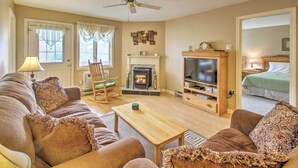A cozy living room with a fireplace, a television, and comfortable seating. - Lincoln Resort Condo w/ Pool Access - Near Hiking! (Lincoln)