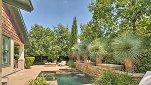 A backyard with a swimming pool, a stone wall, and various plants. - Pool & Hot Tub: Ideally Located 'austin Oasis' (Austin)