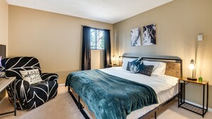 Une chambre à coucher comprenant un lit, une chaise, un bureau et deux lampes fixées au mur.