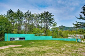 A grassy field with a green fence, a scoreboard, and trees in the background. - Cozy Bartlett Condo w/ Deck & Resort Amenities! (Bartlett)