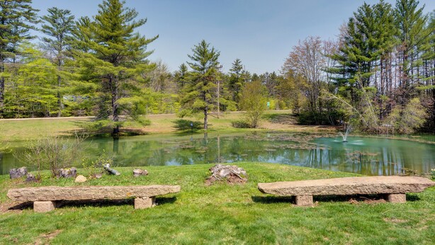 A serene lakeside setting with picnic tables and a pond, surrounded by trees. - Cozy Bartlett Condo w/ Deck & Resort Amenities! (Bartlett)