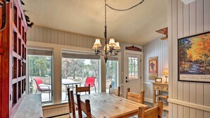 A dining area with a wooden table and chairs, a chandelier, and large windows offering a view of the outdoors. - Ski-in/out Condo! Walk to Main Street Breckenridge (Breckenridge)