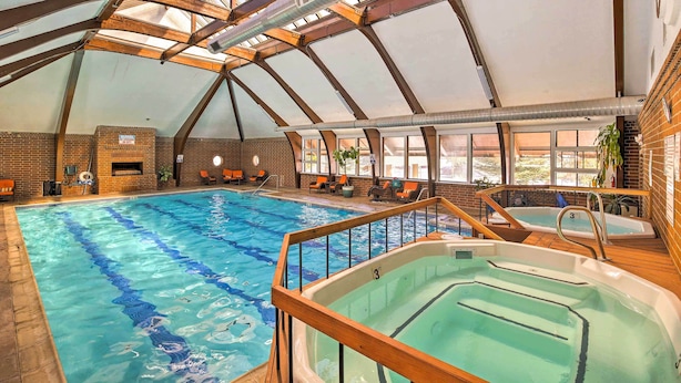 An indoor swimming pool with a high ceiling and skylights, a hot tub, and lounge chairs by the pool. - < 2 Mi to Frisco Adventure Park: Cozy Townhome! (Frisco)