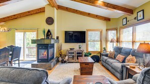 A cozy living room with a fireplace, comfortable seating, and a television. - 1 Mi to Grand Lake: Family-friendly Gem w/ Hot Tub (Grand Lake)