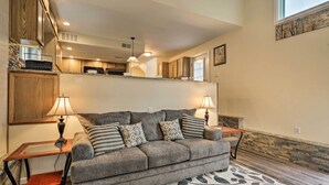 A living room with a grey sofa, two lamps, and a patterned rug.
