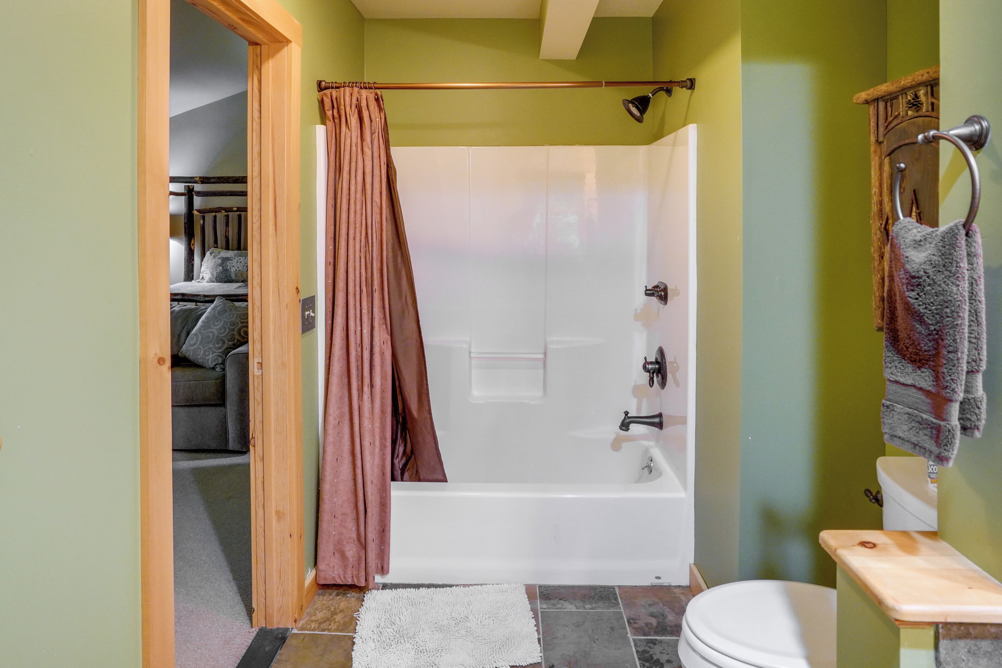 Ein Badezimmer mit Badewanne, Toilette und Duschvorhang.