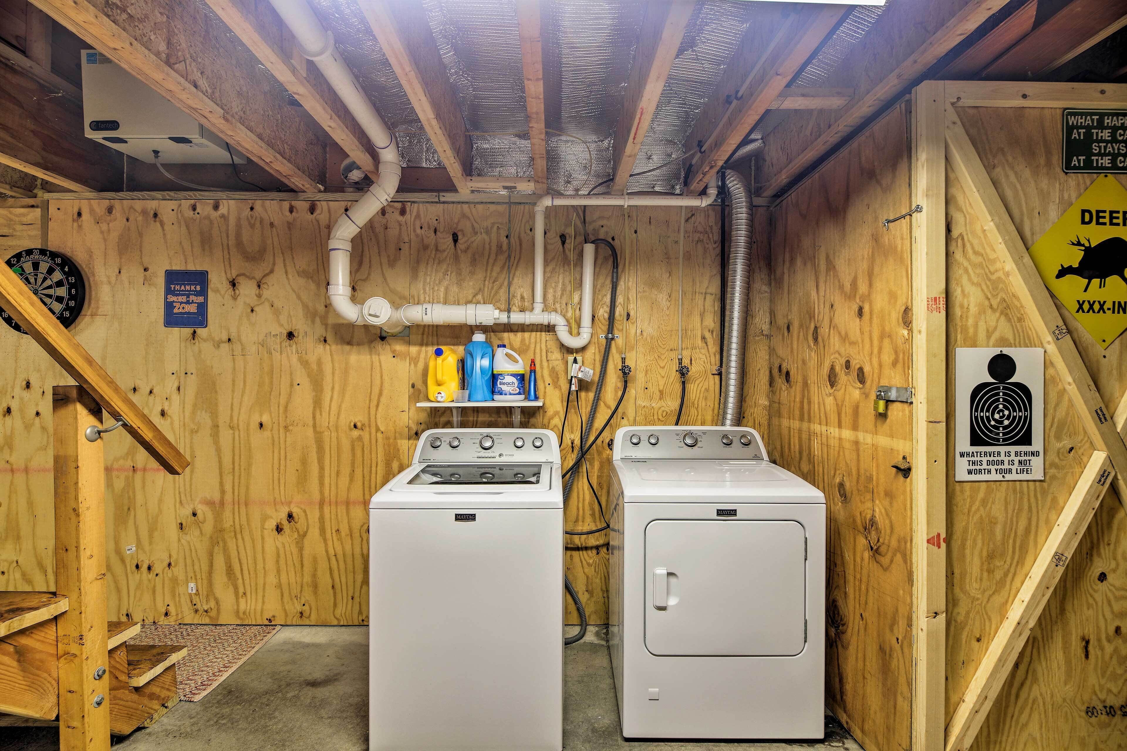 A laundry room with two washing machines, a dartboard, and a sign indicating a smoke-free zone.