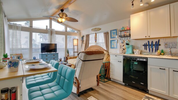 A compact kitchen with a dining area, a ceiling fan, and a dishwasher. - Furnished Deck: Waterfront Port Isabel Cottage! (Port Isabel)