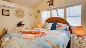 A bedroom with a bed, a nightstand, a wall-mounted shelf, and a window with blinds. - Furnished Deck: Waterfront Port Isabel Cottage! (Port Isabel)