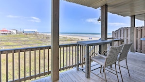 A wooden deck with a table and chairs overlooking a beach. - Near Ocean: Surfside Beach Gem w/ Deck & Views! (Freeport)