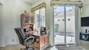 A home office with a desk, chair, and computer. There is a cabinet with glass doors and a television. - 2 Mi to Coachella: Indio Home w/ Fire Pit! (Indio)