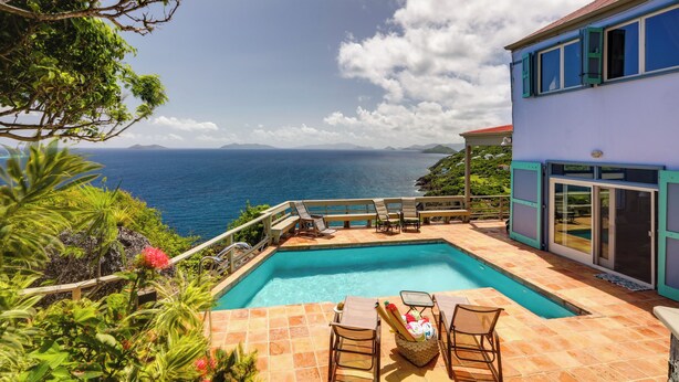 A swimming pool with lounge chairs and a view of the ocean. - St Thomas Cliffside Villa With Pool & Hot Tub! (St. Thomas)