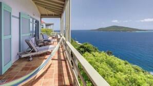 A balcony with a view of the ocean, a hammock, and two lounge chairs. - St Thomas Cliffside Villa With Pool & Hot Tub! (St. Thomas)
