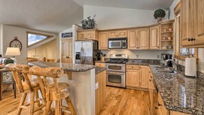 A kitchen with wooden cabinets, granite countertops, a refrigerator, a microwave, a stove, and a sink. - 5 Mi to Ski Resort: Breck Home w/ Hot Tub! (Breckenridge)