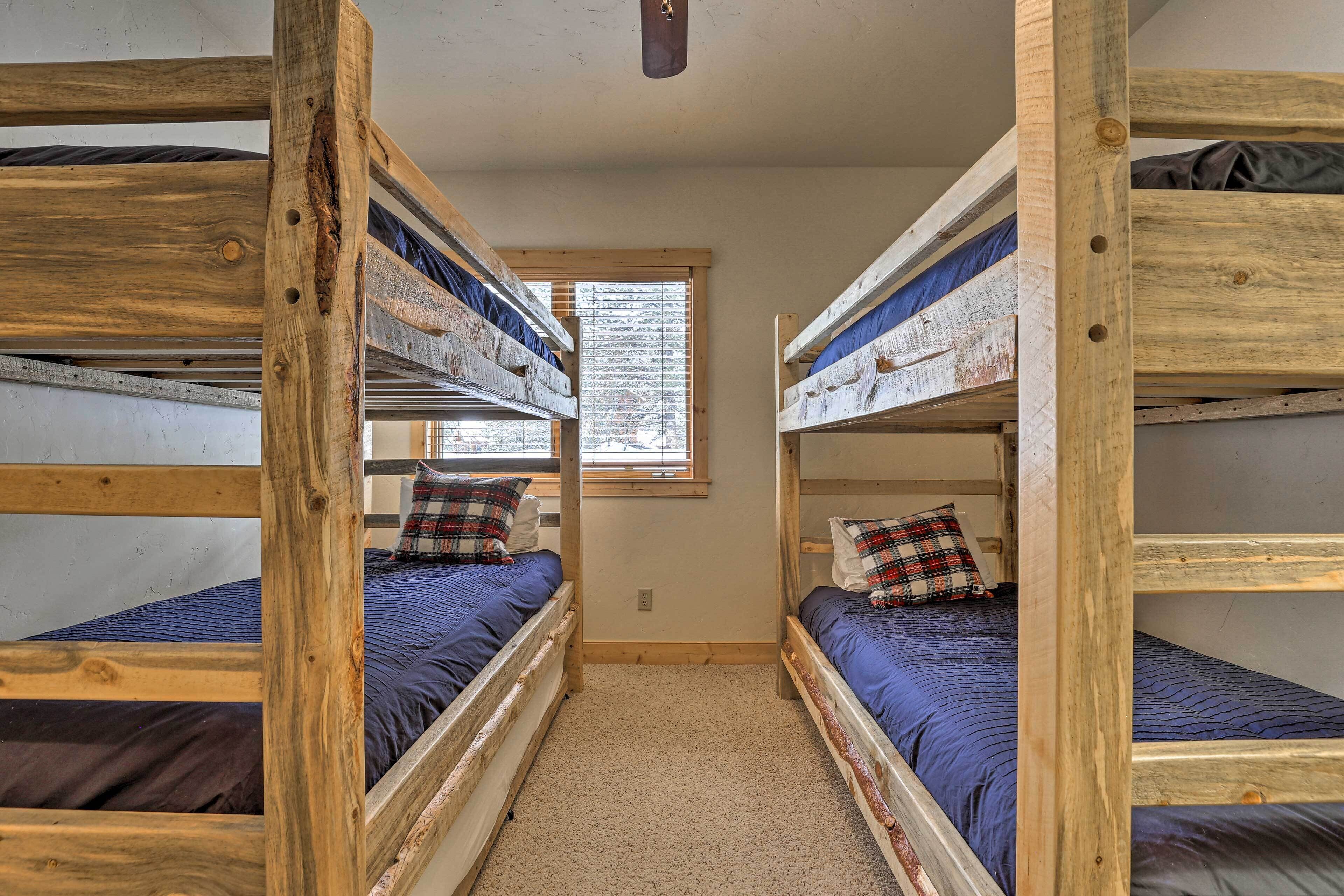Habitación con literas de madera y ropa de cama azul.