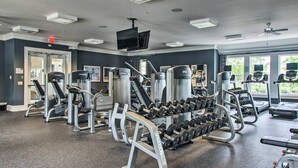 A gym with various exercise equipment, a television, and large windows. - 5 Mi to Bethany Beach: Townhome w/ Community Perks (Millville)