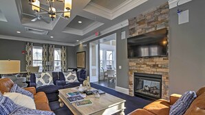 A spacious living room with leather sofas, a coffee table, and a stone fireplace. - 5 Mi to Bethany Beach: Townhome w/ Community Perks (Millville)