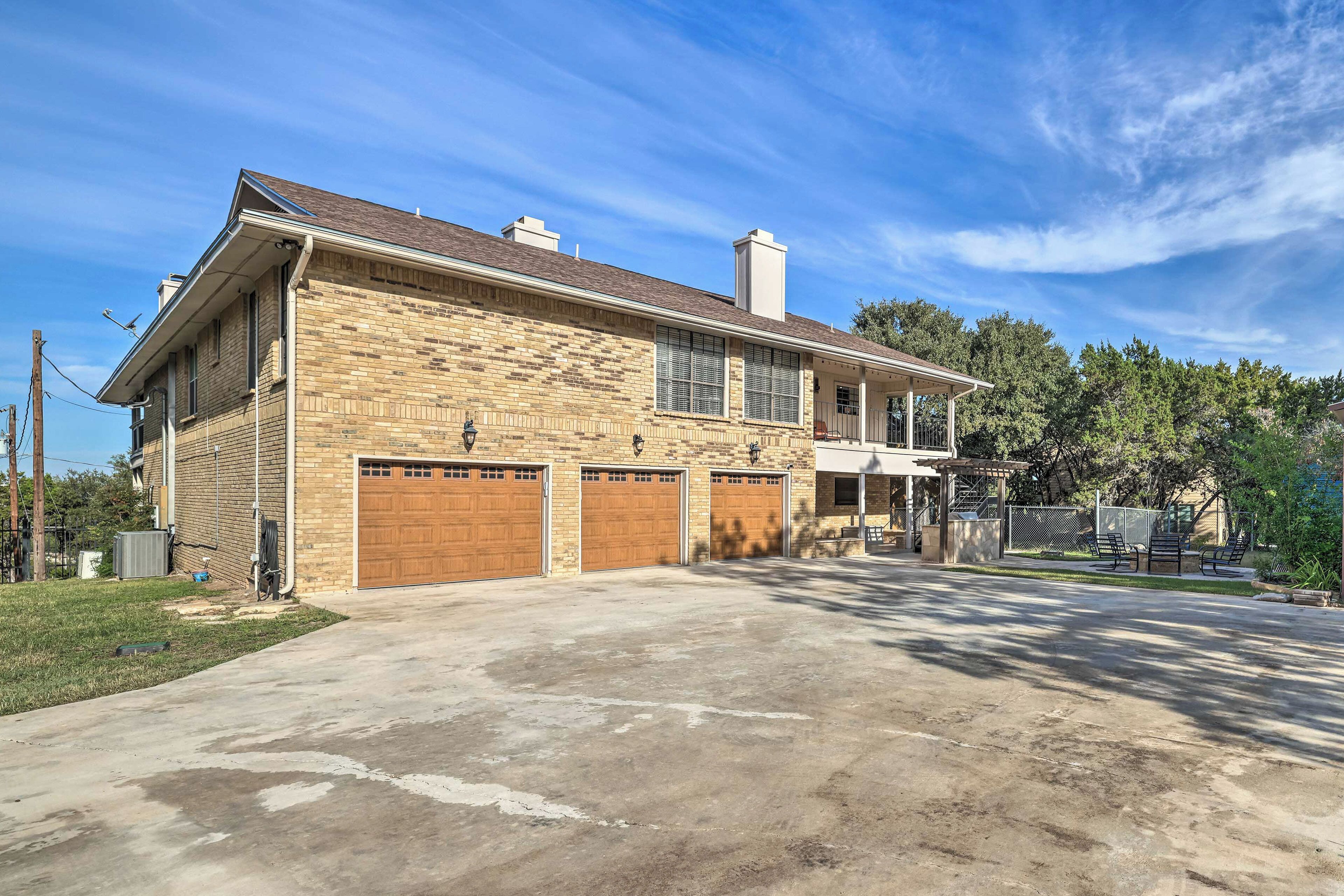 A two-story house with a brick facade, two attached garages, and a covered porch.