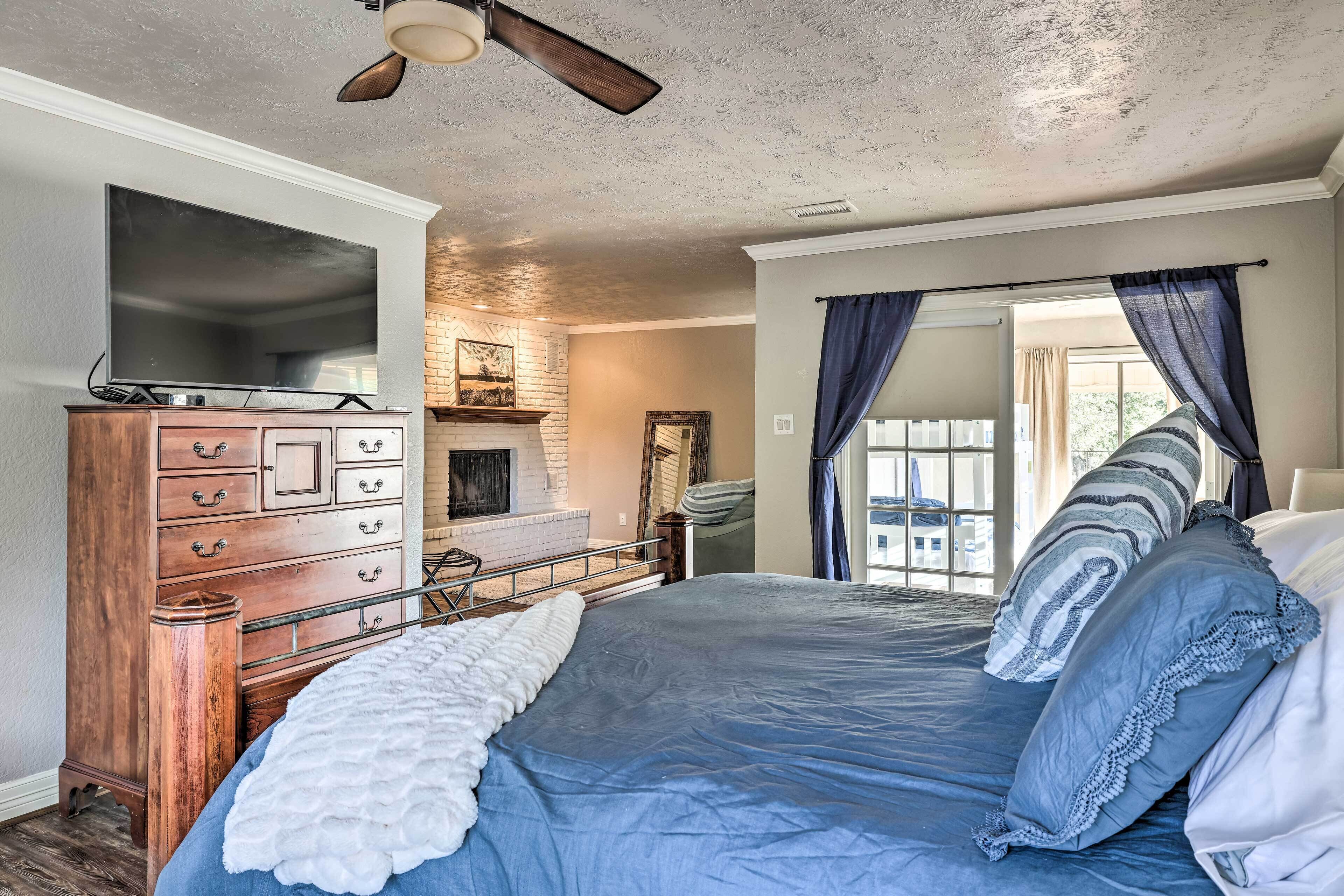 A bedroom with a bed, dresser, and a television.
