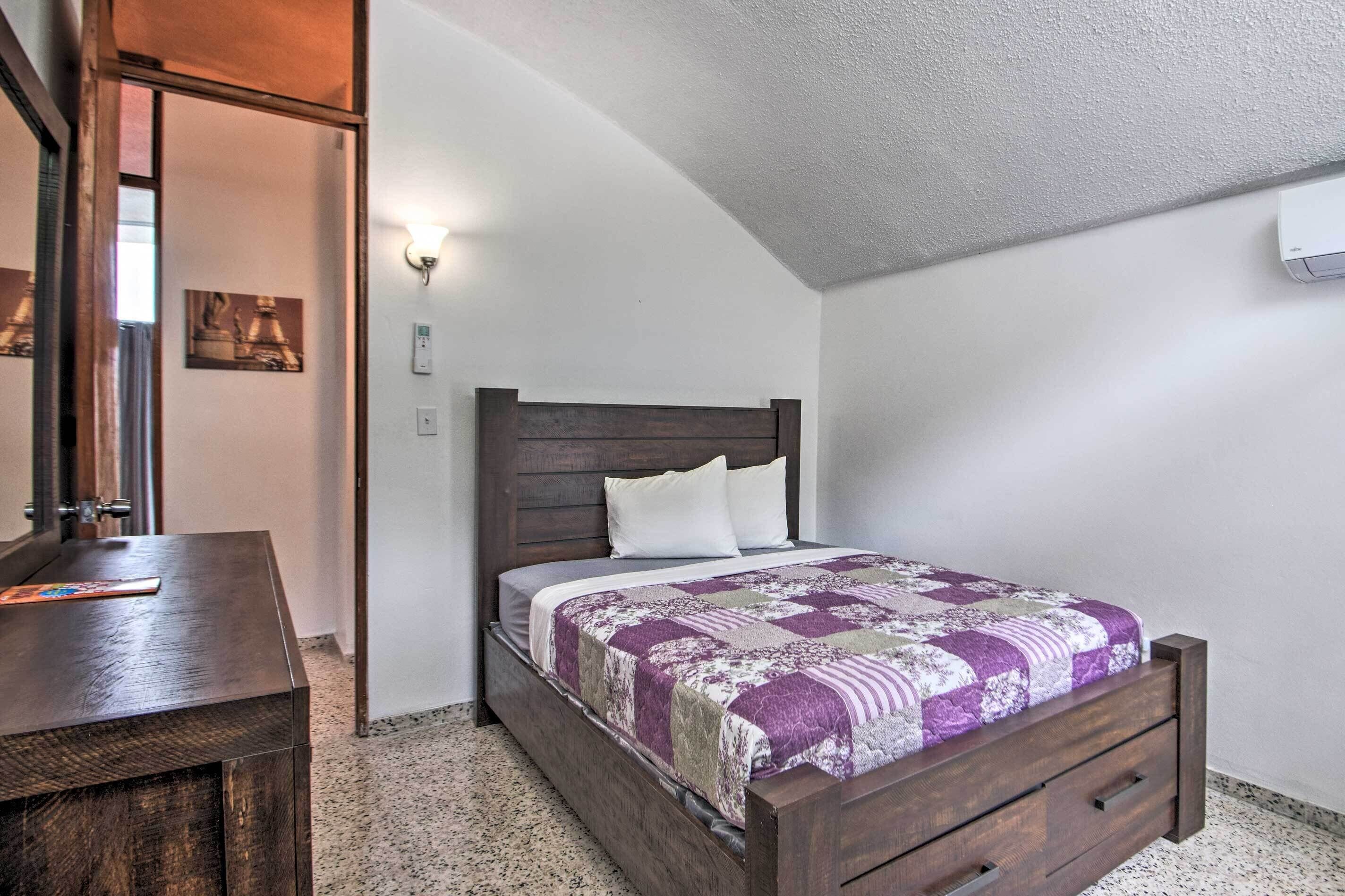 A bedroom with a wooden bed, a nightstand, and a mirror.
