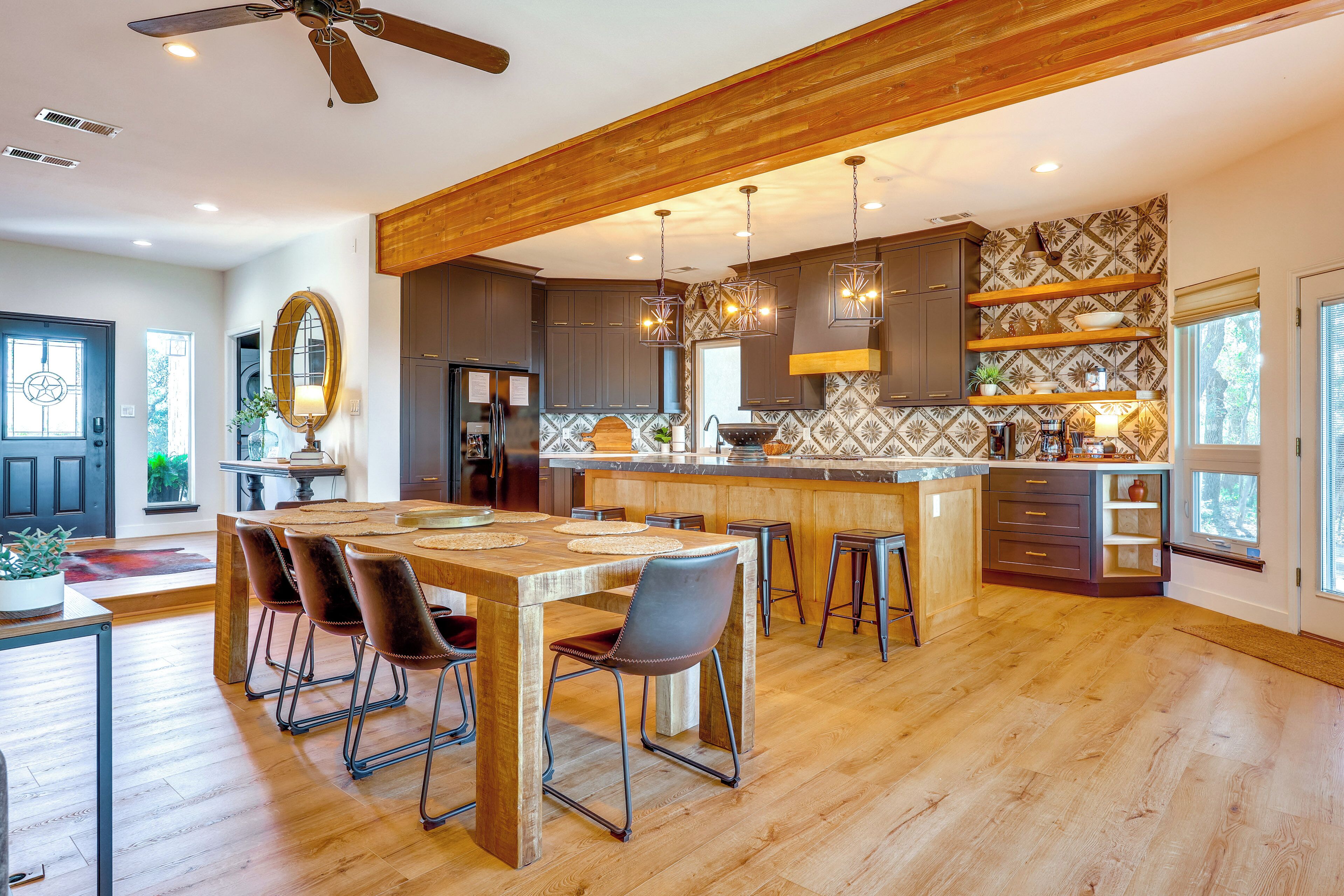 Una cocina amplia con techo de madera, una isla central y taburetes de bar.