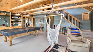A wooden interior with a dining table, a hammock chair, and a staircase. - Grand Jefferson Home w/ Stunning Mtn Views! (Como)