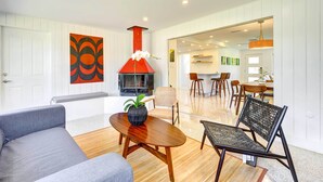 A modern living room with a fireplace, a dining area, and a kitchen in the background. - Charming Sarasota Vacation Home Near Downtown (Sarasota)