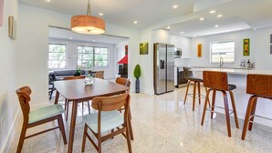 A modern kitchen with stainless steel appliances, wooden chairs, and a dining table. - Charming Sarasota Vacation Home Near Downtown (Sarasota)