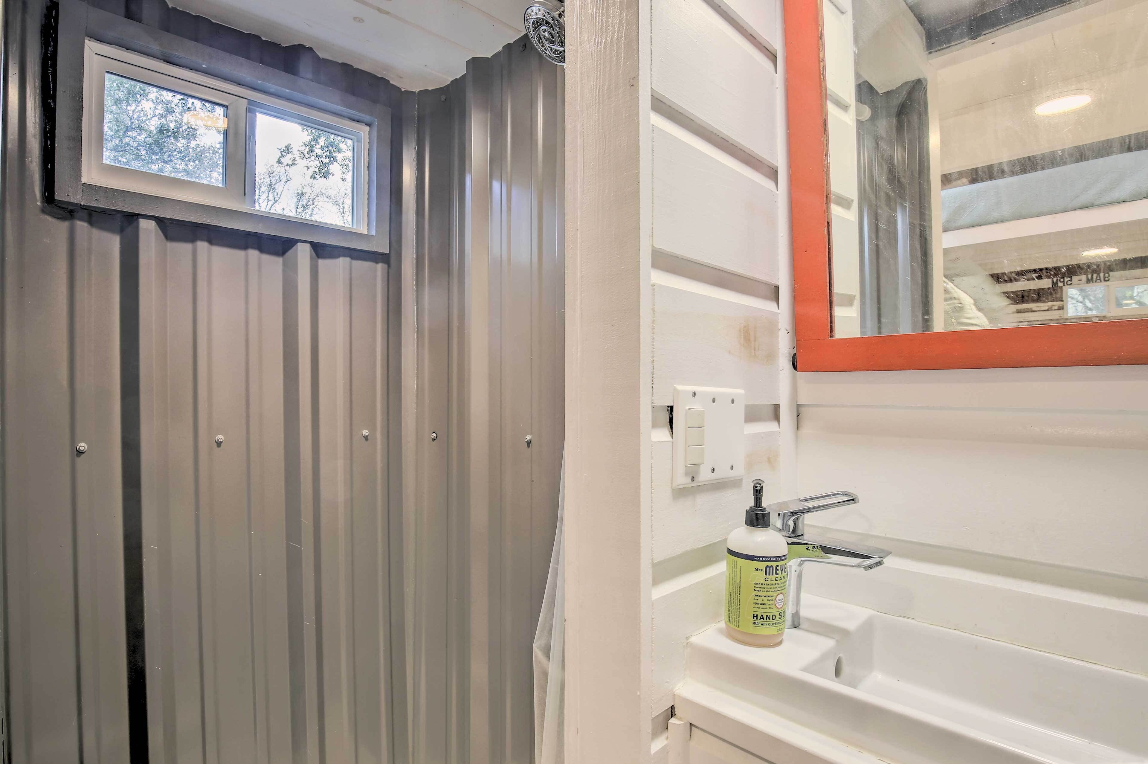 Un bagno con finestra, lavandino e specchio.