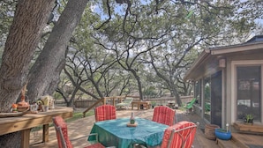 An outdoor deck with a table and chairs, surrounded by trees. - Unique Stay: 'tiny Everest' San Antonio Home! (San Antonio)