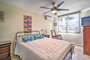 A bedroom with a bed, a ceiling fan, a window, and a dresser.