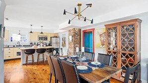 Una cucina moderna con mobili in legno, un'isola centrale e un'area pranzo con tavolo e sedie in legno.
