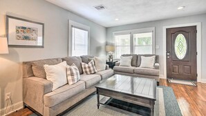 A living room with two sofas, a coffee table, and a door with a stained glass window. - ~ 1 Mi to Pier & Beaches! Family Home in Galveston (Galveston)