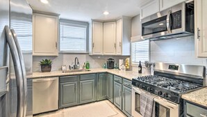 A modern kitchen with stainless steel appliances, light-colored cabinets, and a granite countertop. - ~ 1 Mi to Pier & Beaches! Family Home in Galveston (Galveston)
