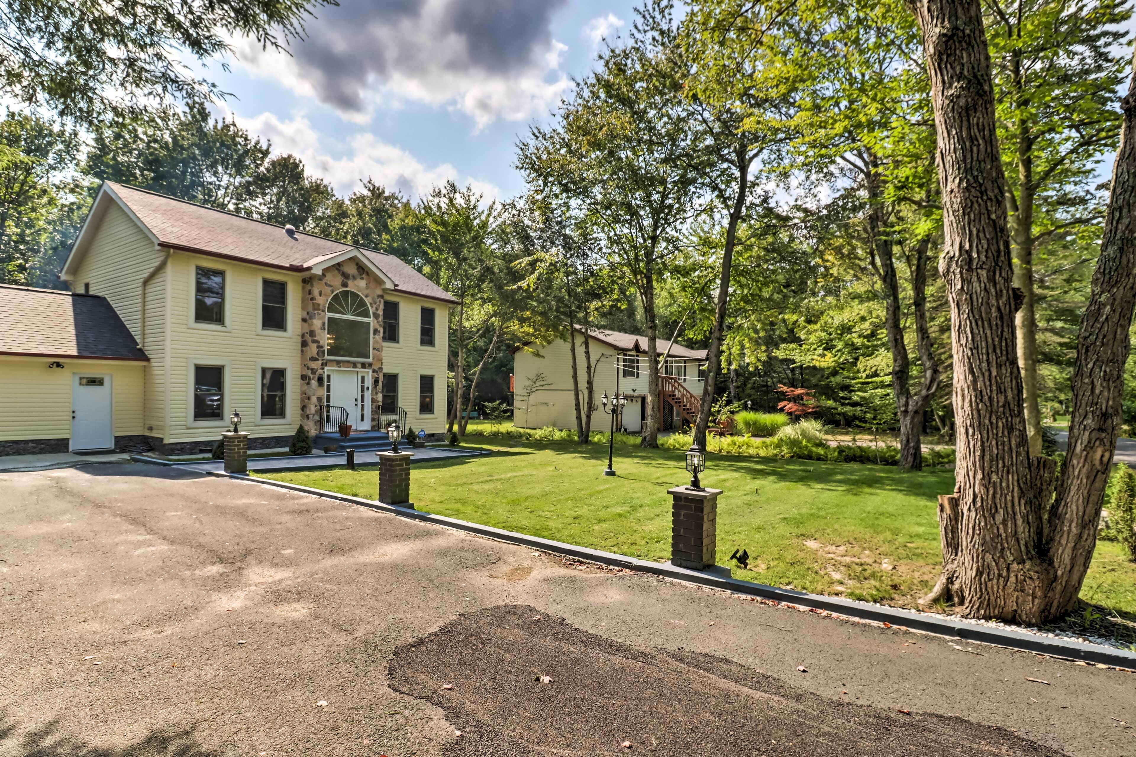 A two-story house with a stone facade, a front porch, and a well-maintained lawn.