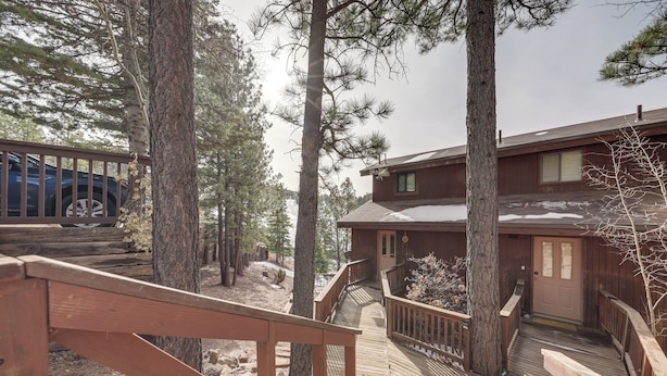 A wooden deck leading to a building surrounded by tall pine trees. - Angel Fire Resort Condo, 400 Feet to Chile Express (Angel Fire)