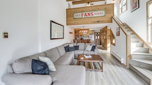 A modern living room with a large sectional sofa, wooden beams, a ceiling fan, and a staircase. - Angel Fire Resort Condo, 400 Feet to Chile Express (Angel Fire)