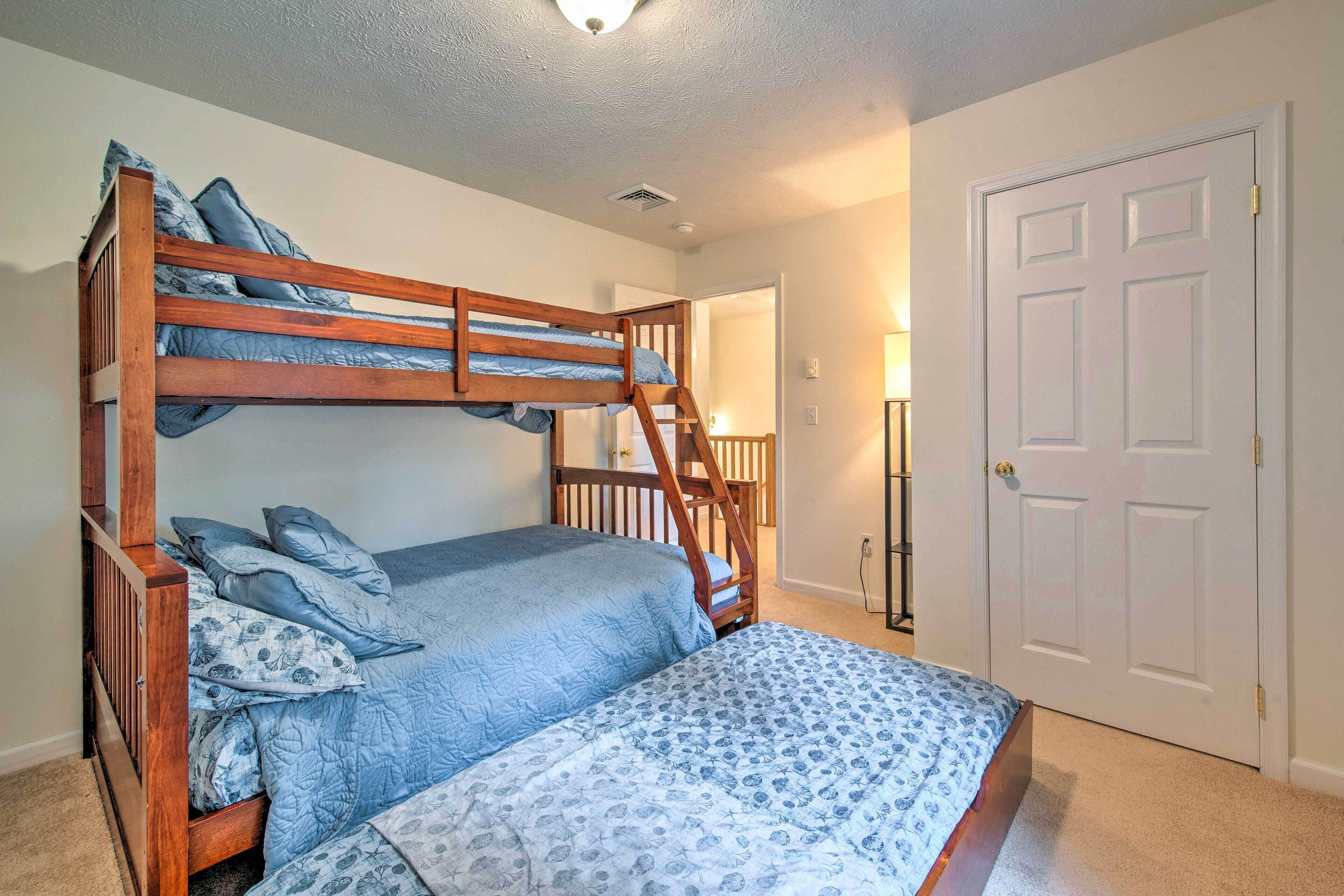 A bunk bed with a ladder, a door, and a lamp in a bedroom.