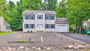 A two-story house with a front porch, a driveway, and a landscaped front yard.