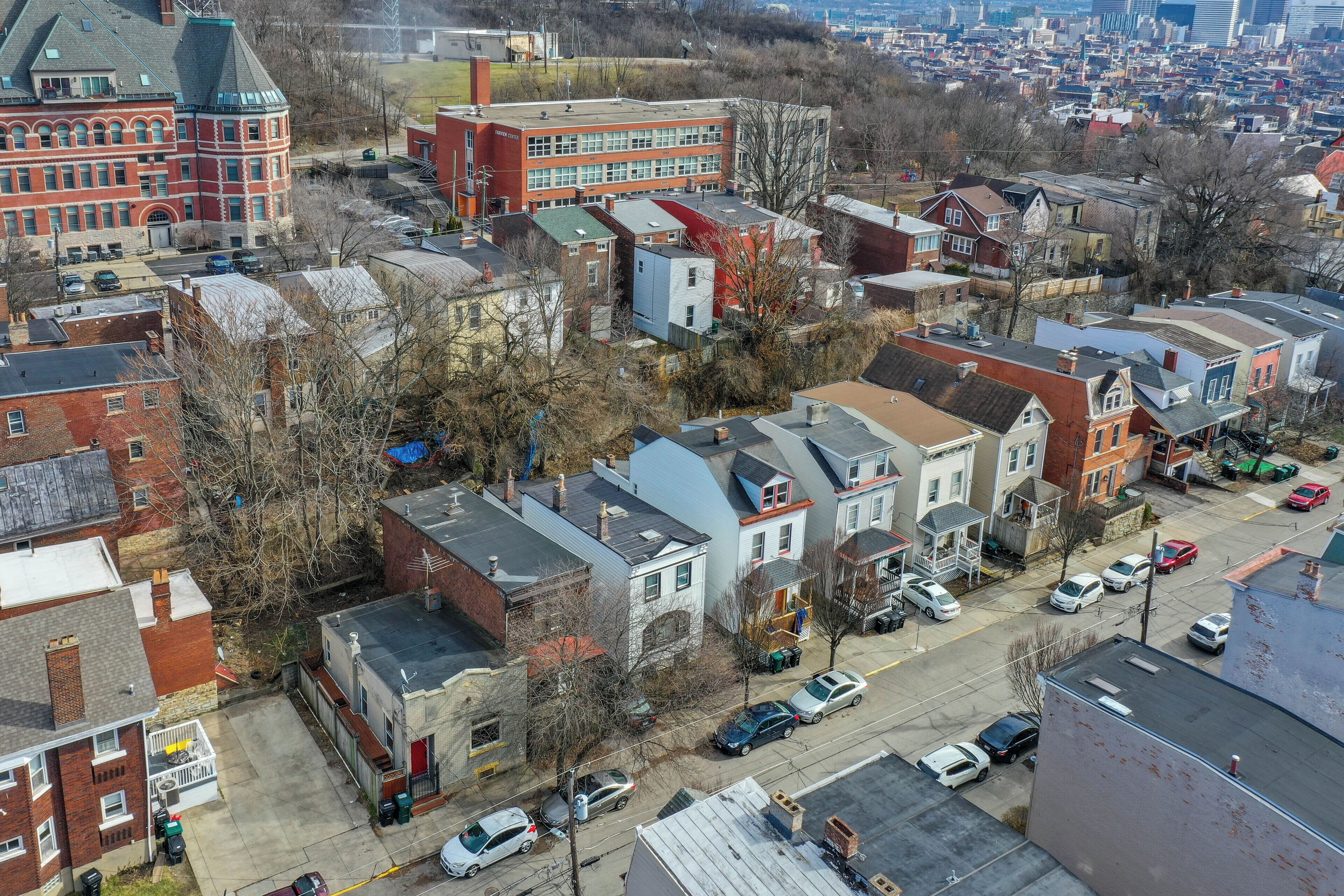 A residential area with various buildings, including a prominent red brick structure and a modern building with a flat roof.