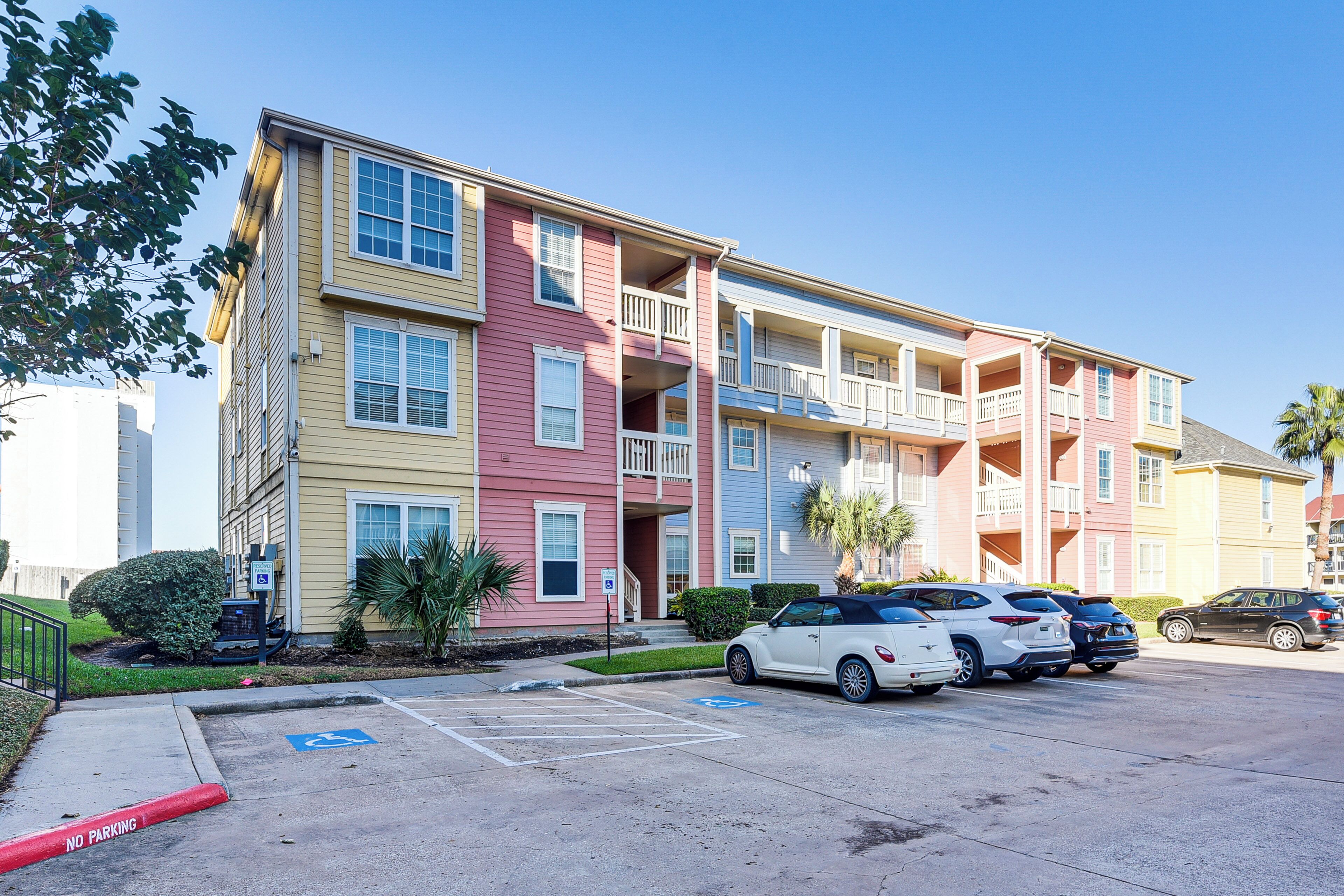 A multi-story apartment building with a parking lot in front.