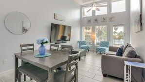 Un salon moderne comprenant un coin repas, un canapé et un téléviseur.