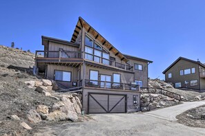 A multi-story building with a large garage, a balcony, and a staircase leading to the upper floor. - Mountain-view House < 2 Mi to Granby Ranch! (Granby)