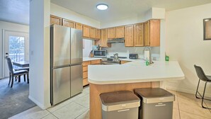 Une cuisine moderne avec des meubles en bois, des appareils électroménagers en acier inoxydable et un îlot central.