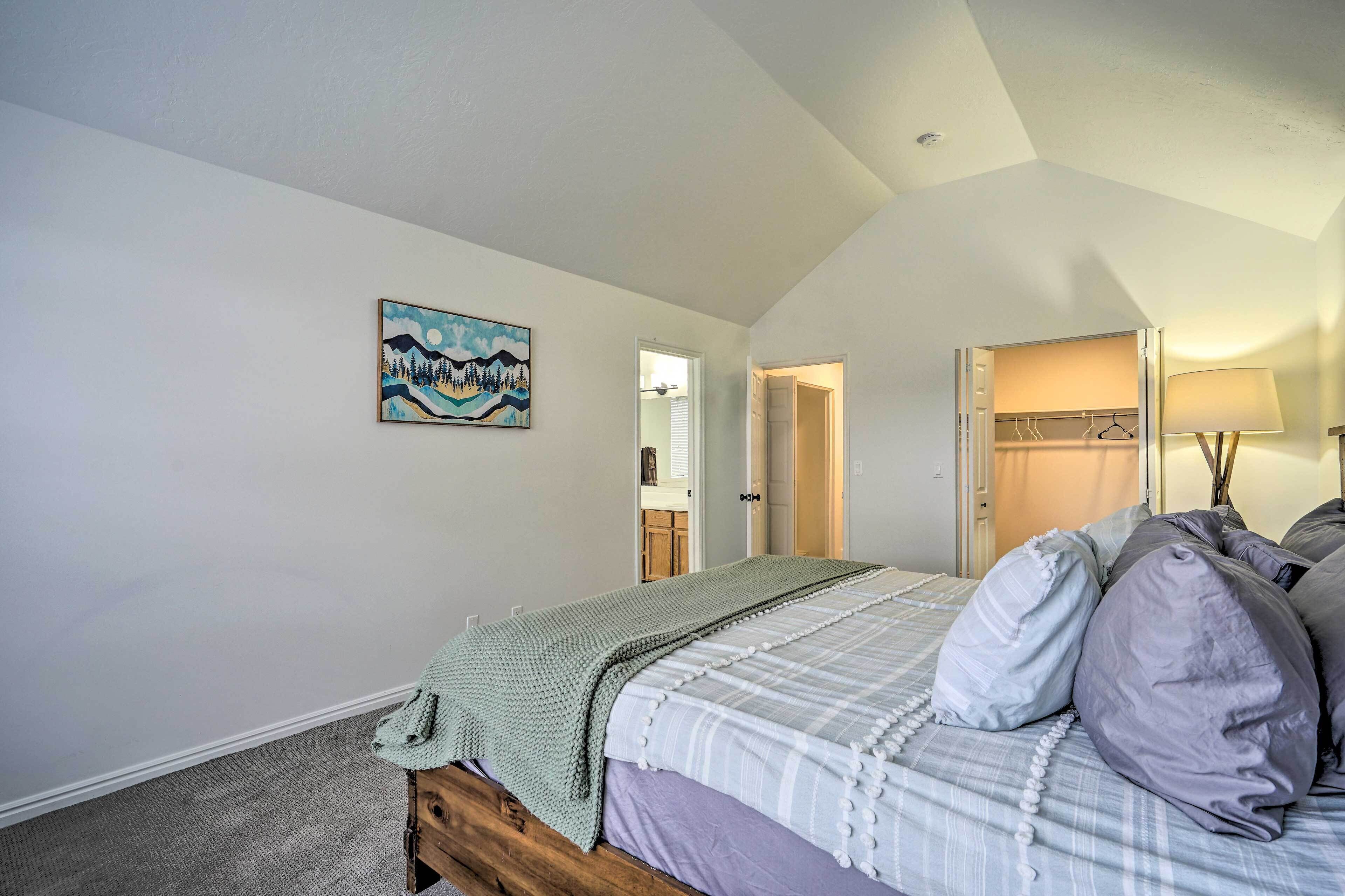 Quarto com cama, quadro, armário e abajur.