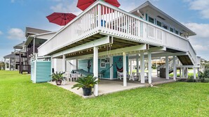 A two-story house with a covered patio, outdoor seating, and a hammock. - Steps to Pirate Beach: Galveston Home w/ Deck! (Galveston)