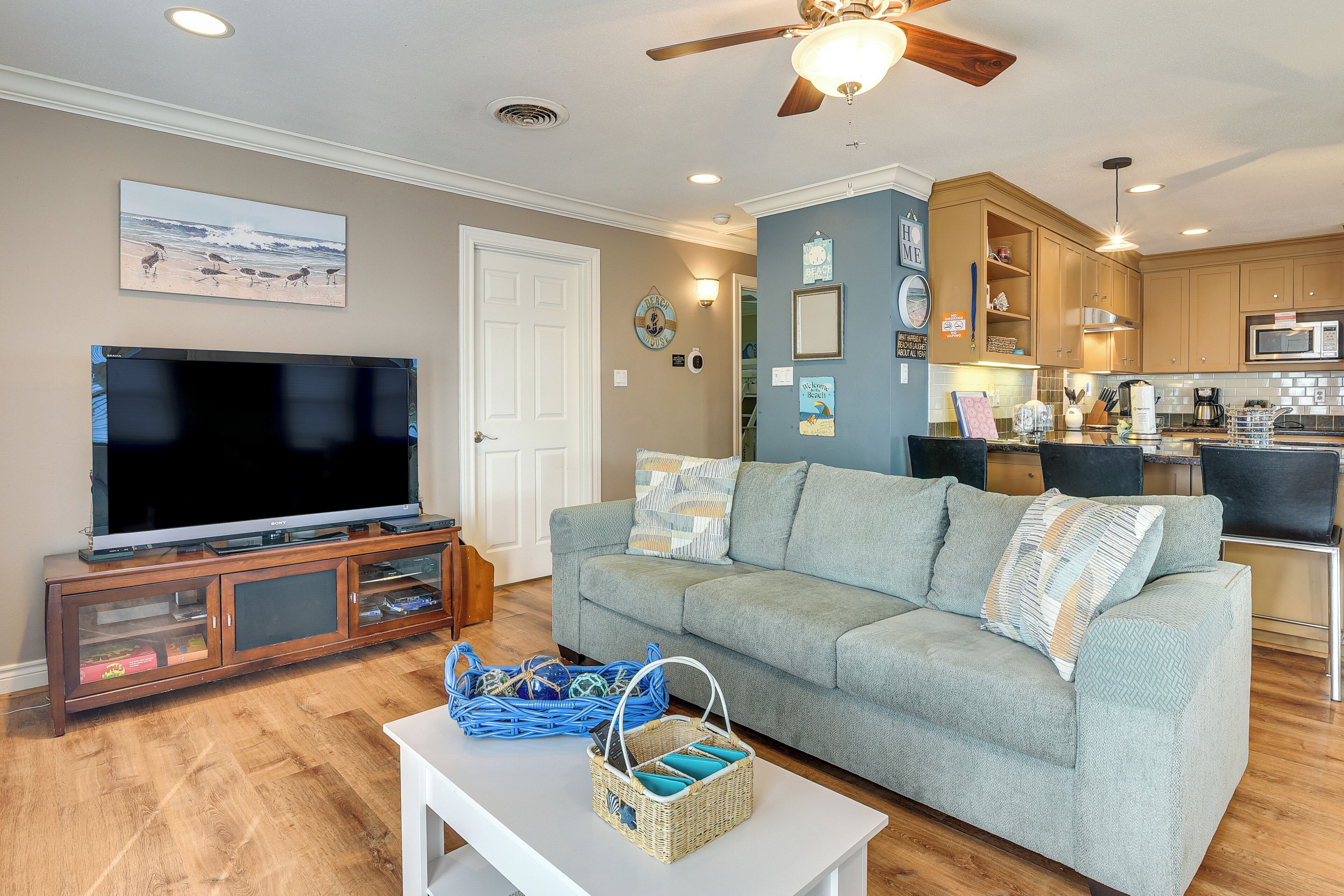 A living room with a television, sofa, and wicker baskets.