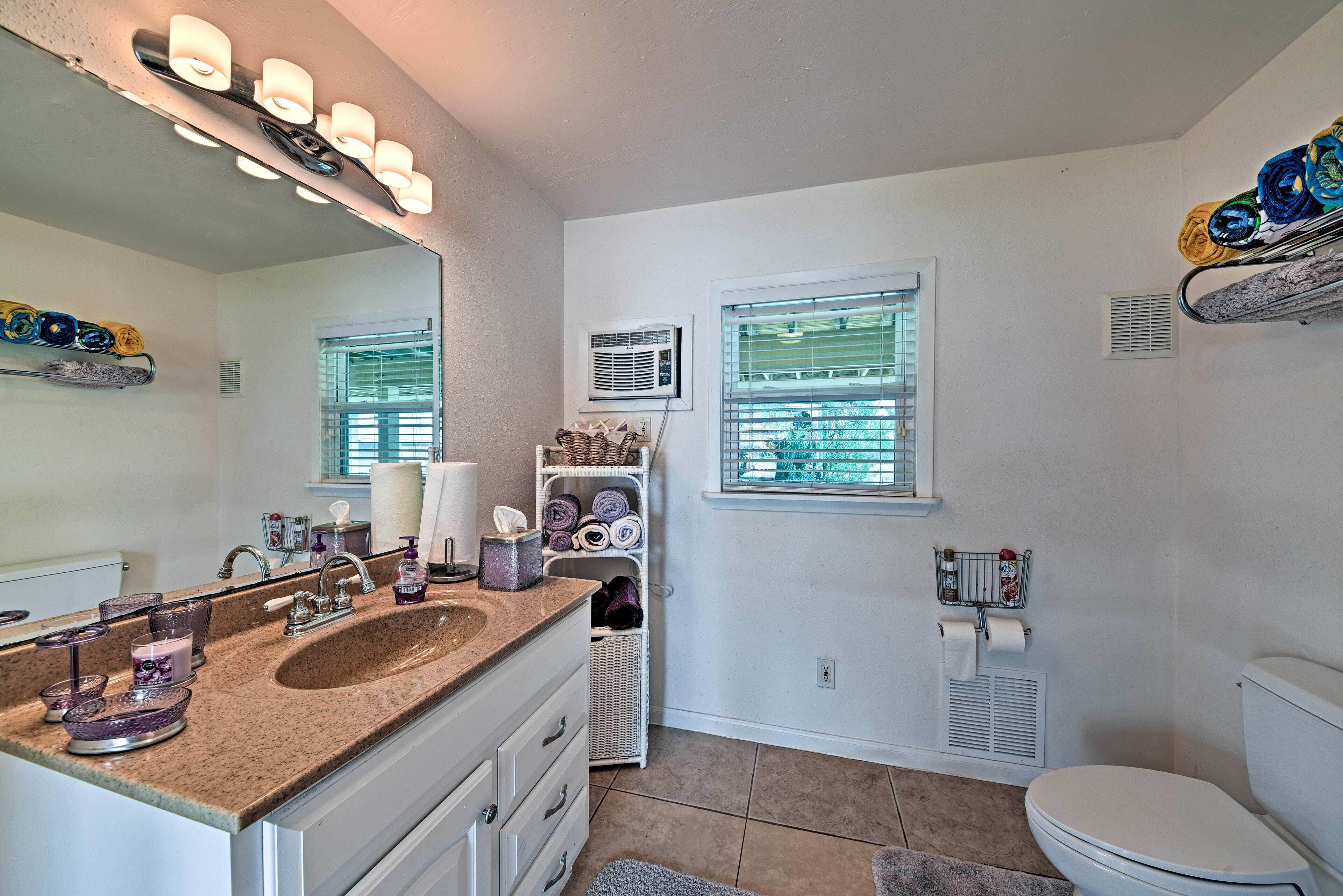 A bathroom with a sink, mirror, towel rack, and toilet.