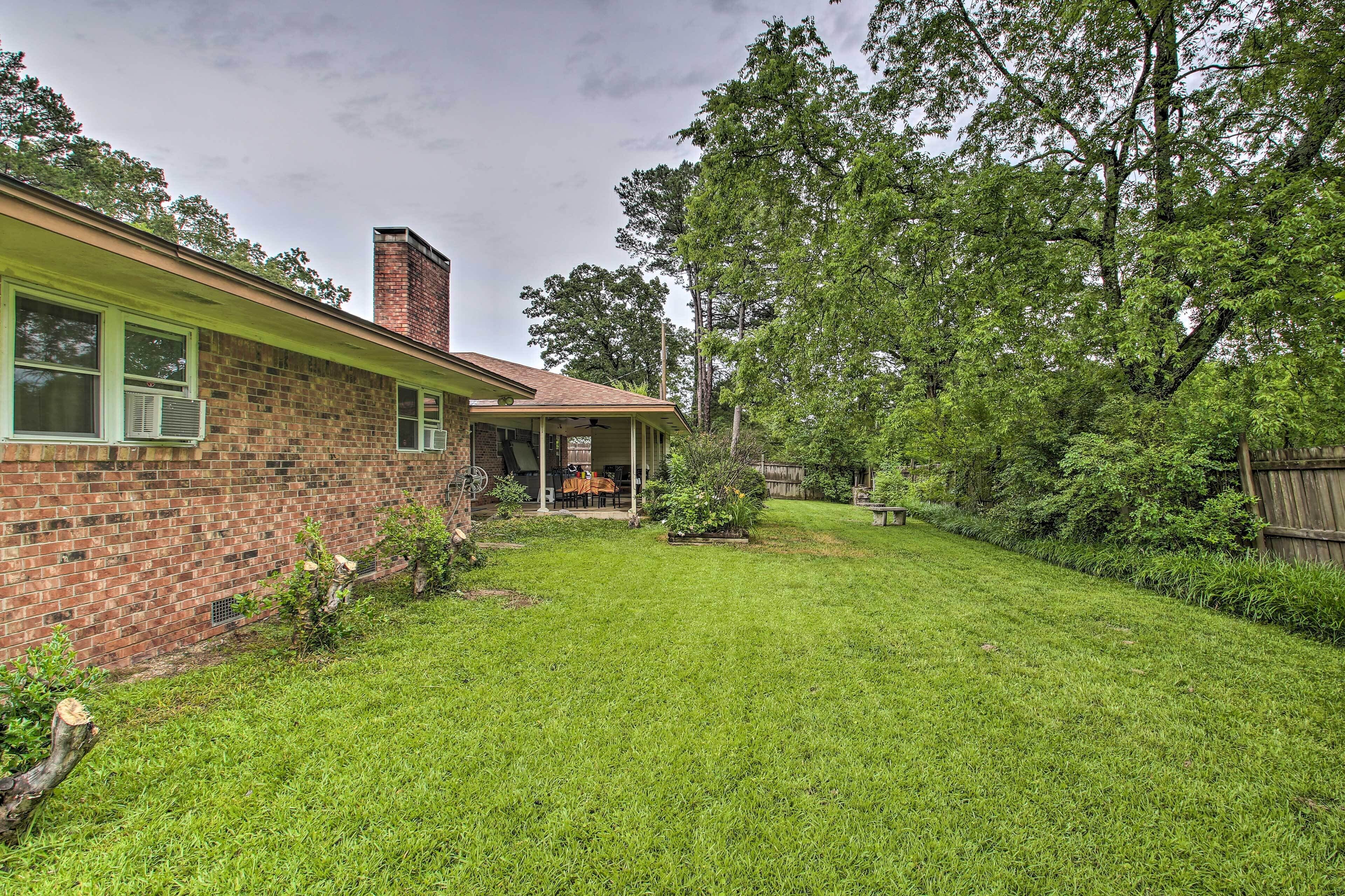 A brick house with a covered porch and a well-maintained lawn.